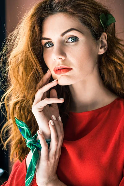 Attractive redhead woman in red dress with hands near face — Stock Photo