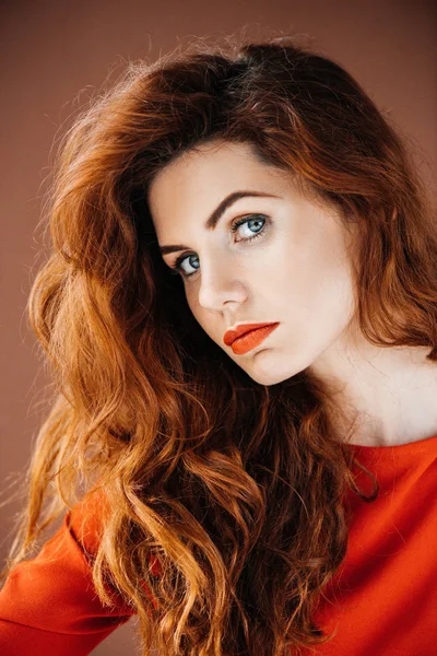 Привлекательная рыжая женщина изолирована на коричневом фоне — стоковое фото