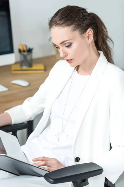 Retrato de hermosa mujer de negocios enfocada leyendo libro en la oficina - foto de stock