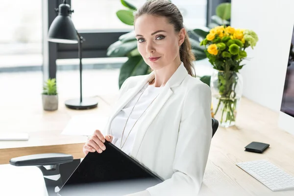 Portrait of smiling businesswoman with book at workplace in office — Stock Photo