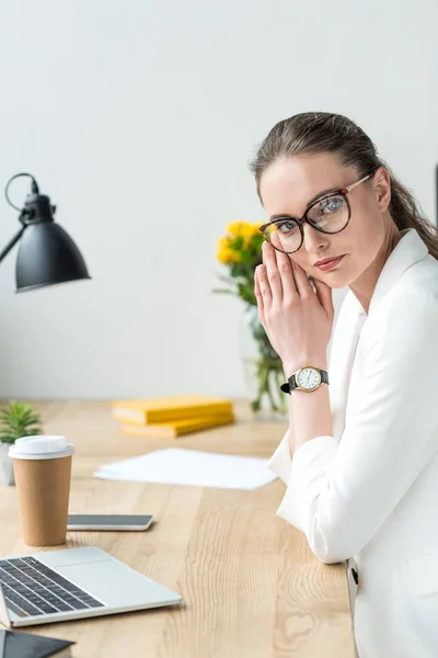 Vista lateral da bela mulher de negócios em terno branco e óculos no local de trabalho no escritório — Fotografia de Stock