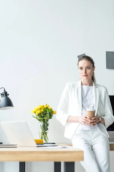 Porträt einer nachdenklichen Geschäftsfrau mit Coffee to go im Büro — Stockfoto