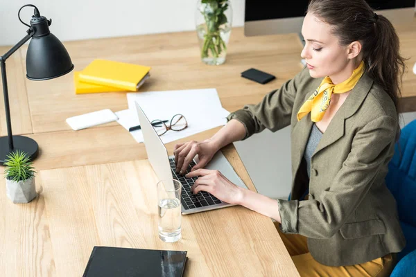 Высокий угол обзора красивой стильной деловой женщины, работающей с ноутбуком в офисе — стоковое фото