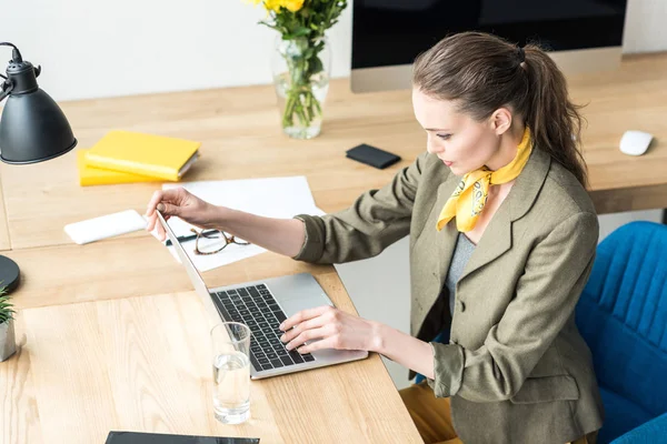 Высокий угол обзора красивой стильной деловой женщины с помощью ноутбука на рабочем месте — стоковое фото