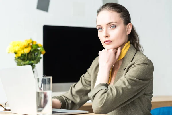 Attractive businesswoman using laptop while sitting at workplace — Stock Photo