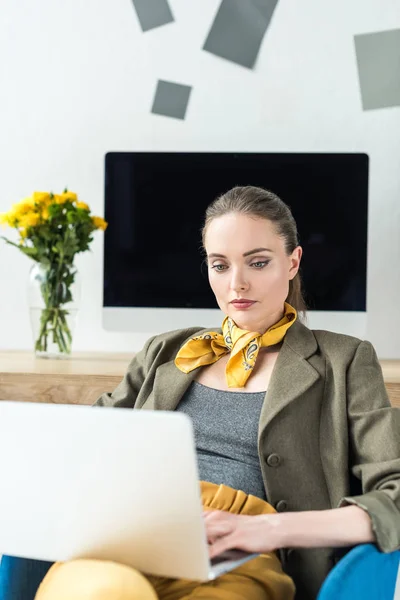 Attractive stylish businesswoman using laptop in office — Stock Photo