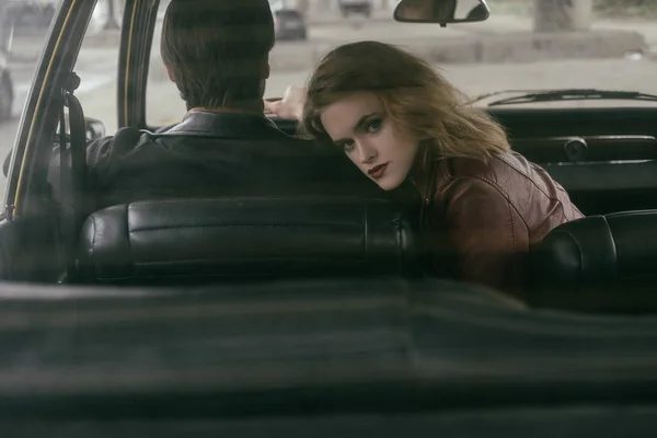 Chica mirando a la cámara a través de la ventana del coche, mientras que el novio coche — Stock Photo