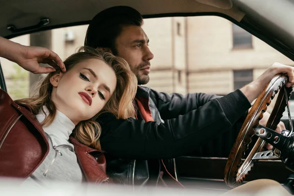 Seductora mujer joven mirando a la cámara mientras el novio de conducción de coches clásicos — Stock Photo