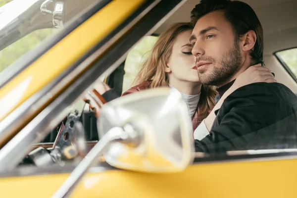 Foco seletivo de jovem casal elegante no amor abraçando no carro — Fotografia de Stock