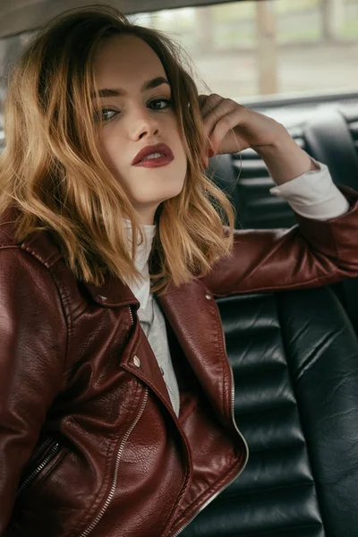 Attractive young woman looking at camera while sitting in car — Stock Photo