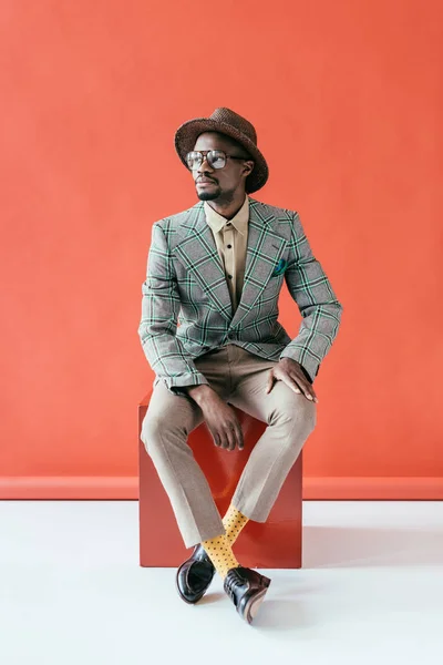 Stylish african american man posing in retro hat, on red — Stock Photo