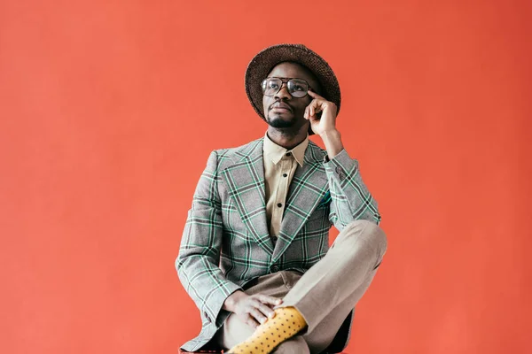 African american man in vintage eyeglasses talking on smartphone, isolated on red — Stock Photo