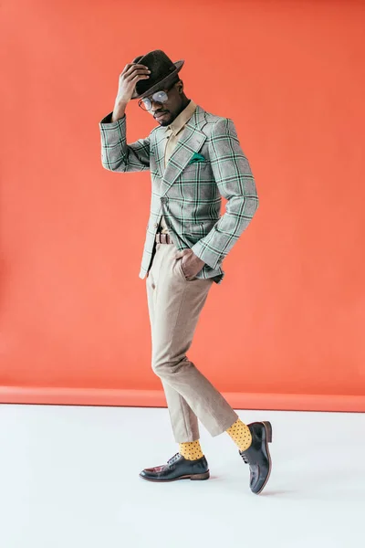 Handsome african american man in vintage hat, on red — Stock Photo