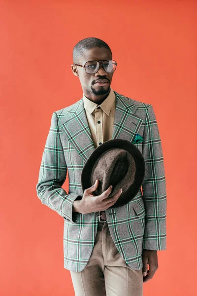 Красивый африканский американец в винтажной шляпе, изолированный на красном — стоковое фото