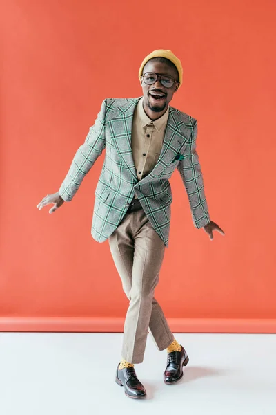 Excited african american man in vintage jacket, on red — Stock Photo