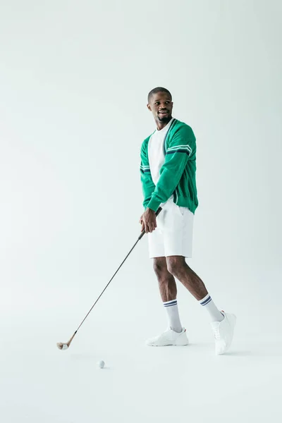 Golfista afroamericano in abbigliamento sportivo vintage gioco, isolato su bianco — Foto stock