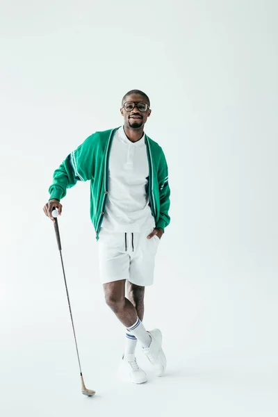 Golfista afroamericano en ropa deportiva retro con club de golf y pelota, aislado en blanco - foto de stock