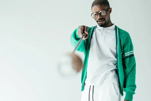 Селективное внимание африканского американца в ретро-зеленой спортивной одежде с клюшкой для гольфа, изолированной на белом — стоковое фото