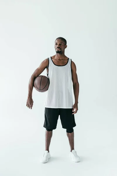 Schöner afrikanisch-amerikanischer Mann in Sportbekleidung mit Basketballkorb, isoliert auf weiß — Stockfoto