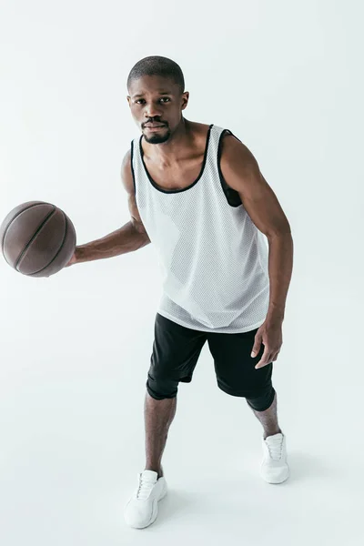 Hombre afroamericano guapo jugando baloncesto, aislado en blanco - foto de stock
