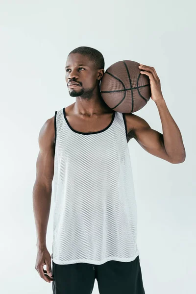 Apuesto jugador de baloncesto afroamericano en ropa deportiva con pelota, aislado en blanco - foto de stock