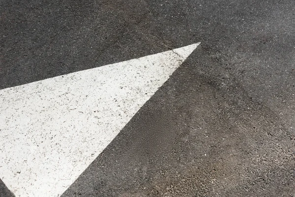 Freccia dipinta di bianco su strada asfaltata — Foto stock