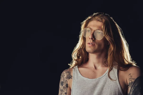 Portrait of man with long hair in stylish eyeglasses, isolated on black — Stock Photo