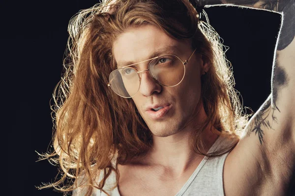Portrait of fashionable man with long hair in stylish glasses, isolated on black — Stock Photo