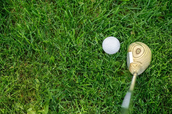 Vista superior del club de golf y pelota sobre hierba verde - foto de stock