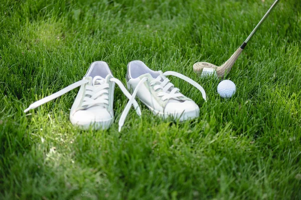 Vista de perto do equipamento de golfe e sapatos brancos em campo verde — Fotografia de Stock