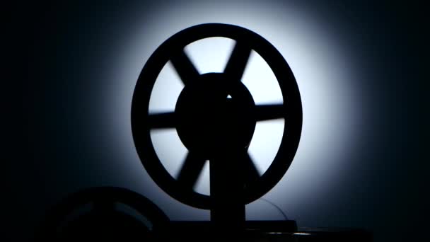 Bobbin movie projector reels film. Silhouette in a dark studio — Stock Video