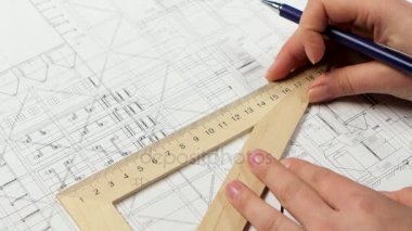 Cetvel kullanan kız bina için yeni çizgiler çizer. Yakın çekim