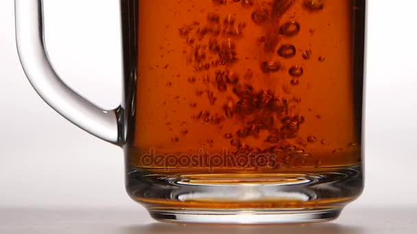 Small bubbles in cup of black tea. Slow motion, closeups