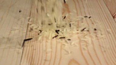 Pirinç ahşap bir masaya düşer ve çevresinde üzerine döktü. Ağır çekim. Yakın çekim