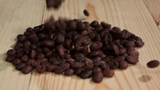 Grano de café fresco cae sobre la mesa y se desmorona. De cerca. Movimiento lento — Vídeos de Stock