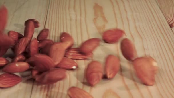 Almonds pour on the table and crumble. Close up. Slow motion — Stock Video