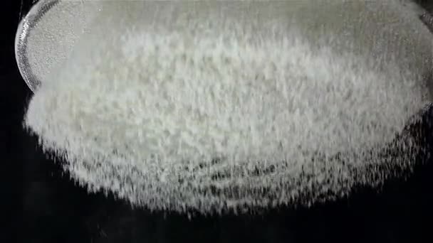 Setaccio piatto setacciato a farina, fondo nero. Rallentatore, vista dal basso — Video Stock