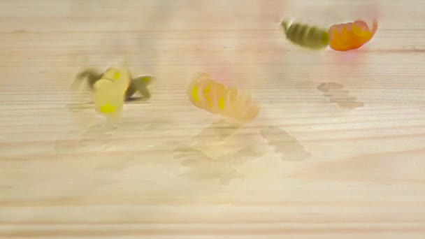Spirální tvar těstovin spadá na dřevěný stůl, pomalý pohyb — Stock video
