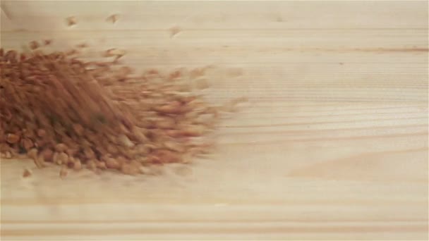 Grains of buckwheat in slow motion falling on table. Closeup — Stock Video