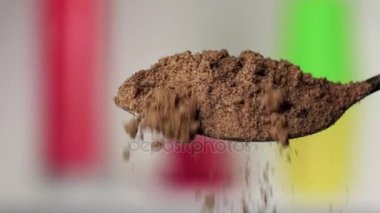 Gümüş kaşık gelen düşen zerdeçal tozu. Arka plan bulanık. Ağır çekim