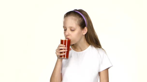 Mała dziewczynka pije sok pomidorowy i podziwia go i pokazuje klasę. Białe tło — Wideo stockowe