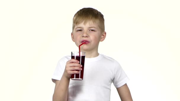 Ребенок пьет гранатовый сок, и ему это нравится. Белый фон. Медленное движение — стоковое видео