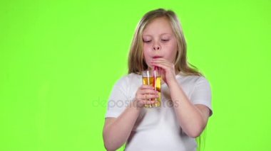 Küçük kız bir saman elma suyu içer. Yeşil ekran. Ağır çekim