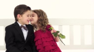 Çocuk bir salıncağa otur ve konuş, kızları bir gül el. Beyaz arka plan. Ağır çekim. Yakın çekim