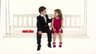 Küçük bir çocuk onun kız arkadaşı onun saç düzeltiyor ve onun titreyen kucaklar. Beyaz arka plan. Ağır çekim