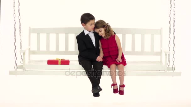Little boy straightens his hair to his girlfriend and embraces her trembling. White background. Slow motion — Stock Video