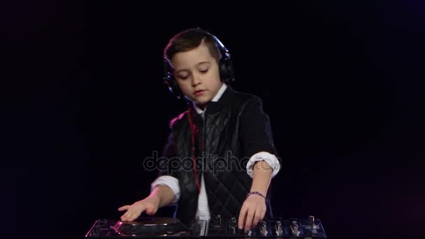 Cool boy dj in headphones playing on vinyl. Black background — Stock Video