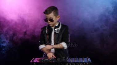 Şık çocuk dj vinil oynarken gözlüklü. Dumanlı arka plan