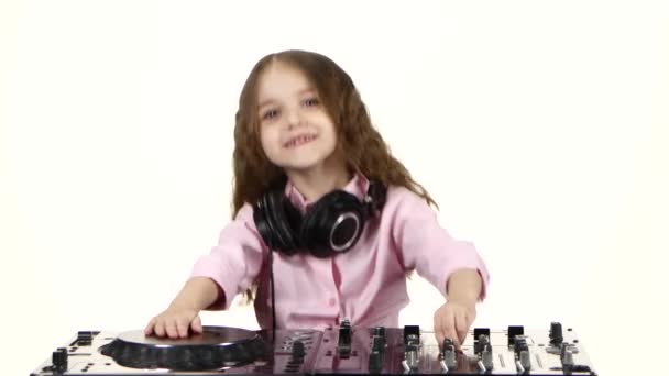 Sladká dívka s kadeřemi hraje dj tabulku. Bílé pozadí — Stock video