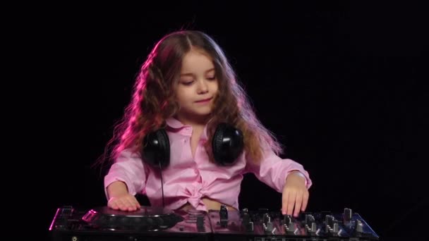 Sweet girl joue sur la console DJ. Fond noir, ralenti — Video